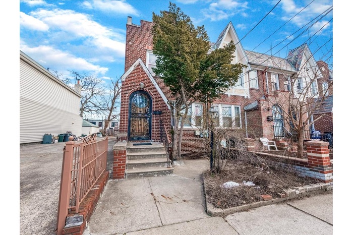 View of front of house with a fenced front yard and brick siding