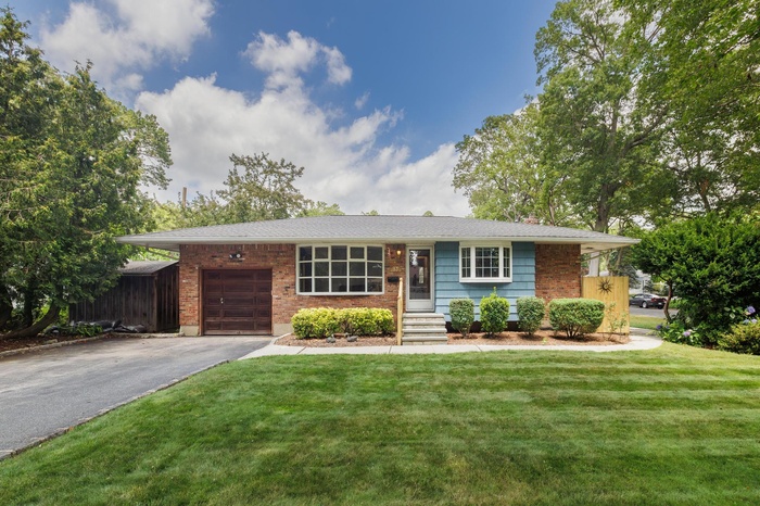 Single story home with a garage, asphalt driveway, and brick siding