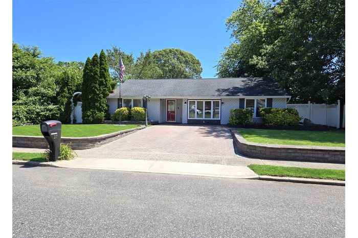 Ranch-style house with decorative driveway and roof with shingles