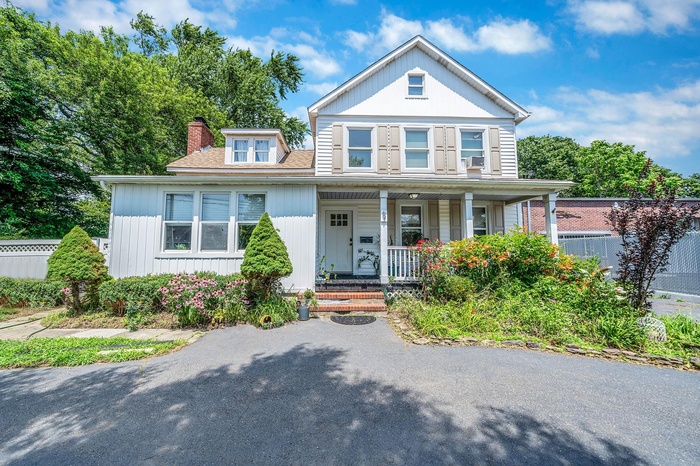 View of front of home featuring a porch and a chimney