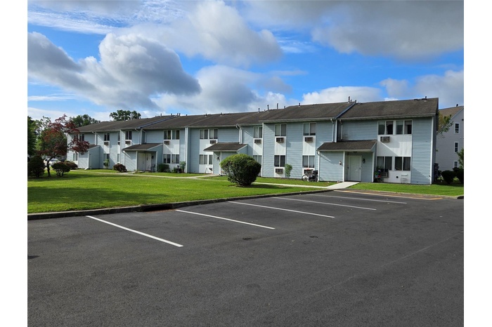 View of property featuring uncovered parking and a residential view