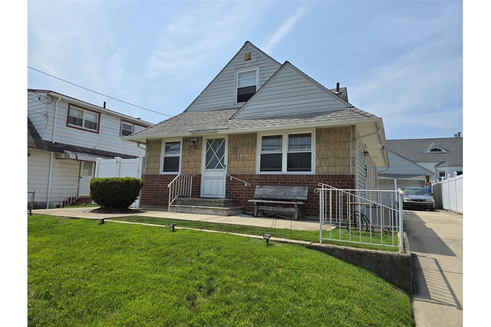 Beautiful landscaped home with front porch, a long Driveway and a one car Garage shingles, and a chimney