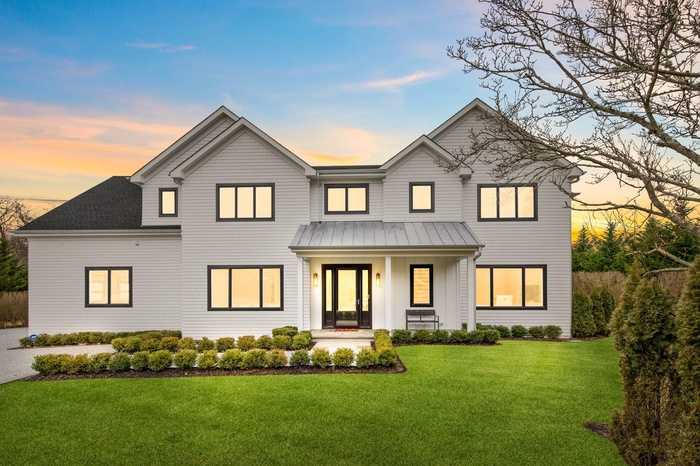 Modern farmhouse style home with a porch, a standing seam roof, a yard, and metal roof