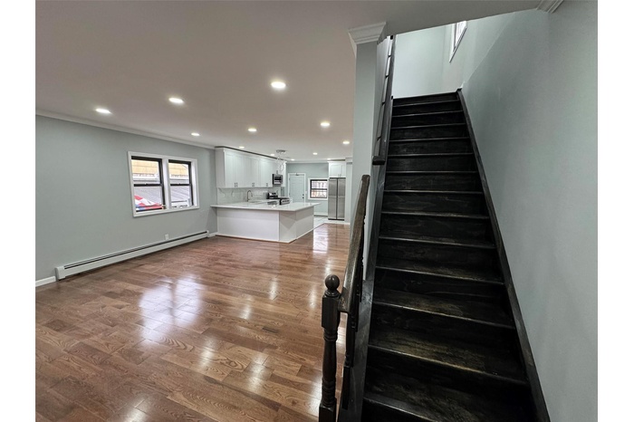 Stairs featuring crown molding, recessed lighting, baseboard heating, baseboards, and wood finished floors