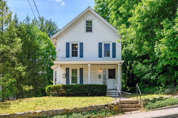 View of front facade with a porch and a front lawn