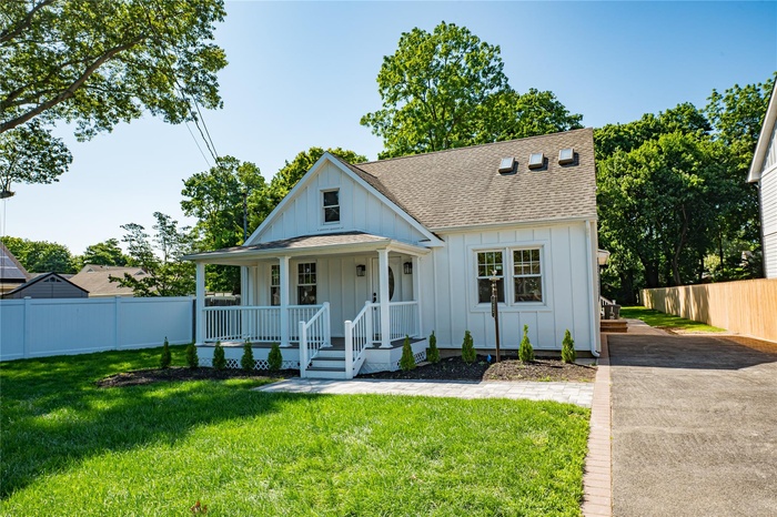 Modern farmhouse style home with board and batten siding, a shingled roof, and a porch