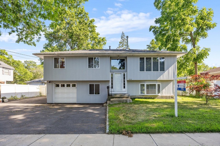 Bi-level home with asphalt driveway
