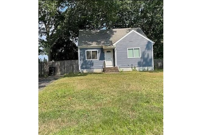 View of front of house featuring a front yard, entry steps, and fence