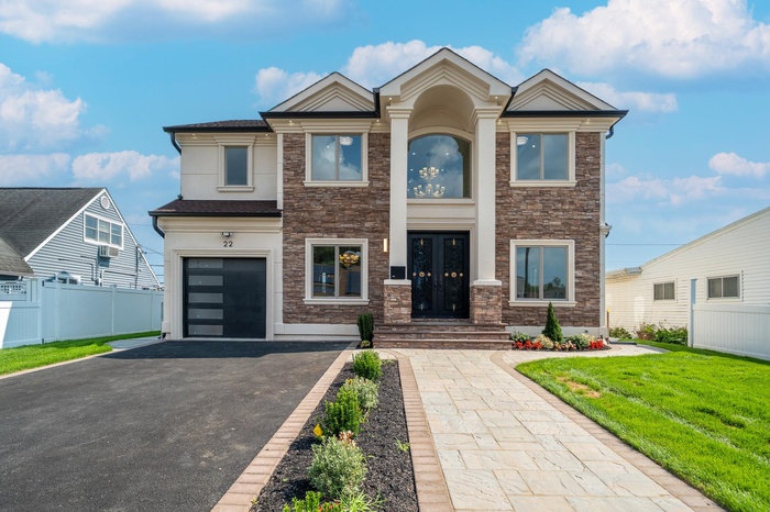 View of front of home featuring stone siding, asphalt driveway, stucco siding, french doors, and an attached garage