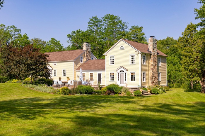 Rear view of house with a chimney, a yard, and outdoor lounge area