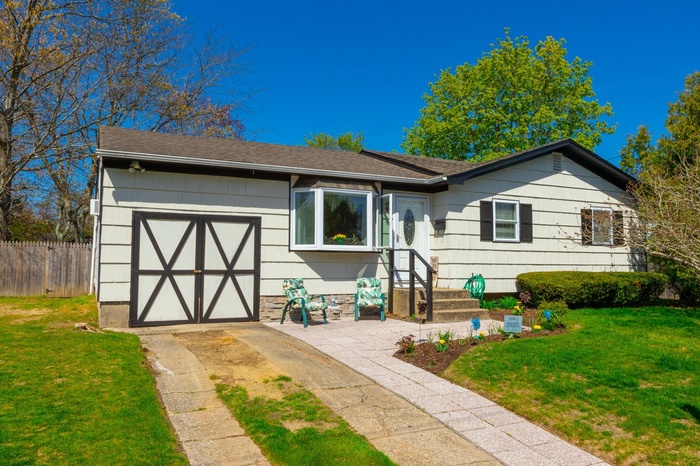 View of front of house featuring a garage, fence, a front yard, roof with shingles, and concrete driveway
