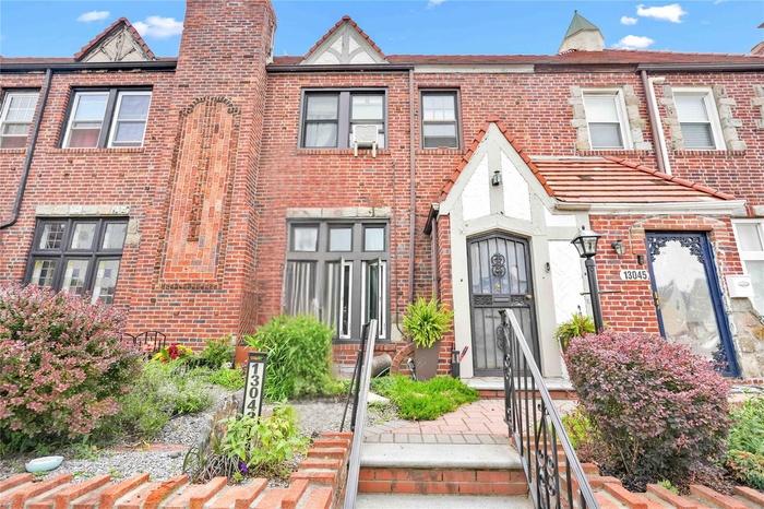 Townhome / multi-family property featuring brick siding and a chimney