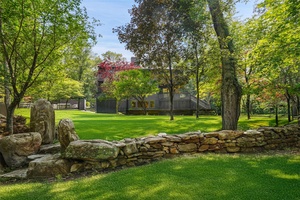 Fully renovated modern on storybook land in Pound Ridge with picturesque pond, walking trails, footbridges, natural rock outcroppings, and a gorgeous Shoreline Pool with built in spa and automatic cover.
