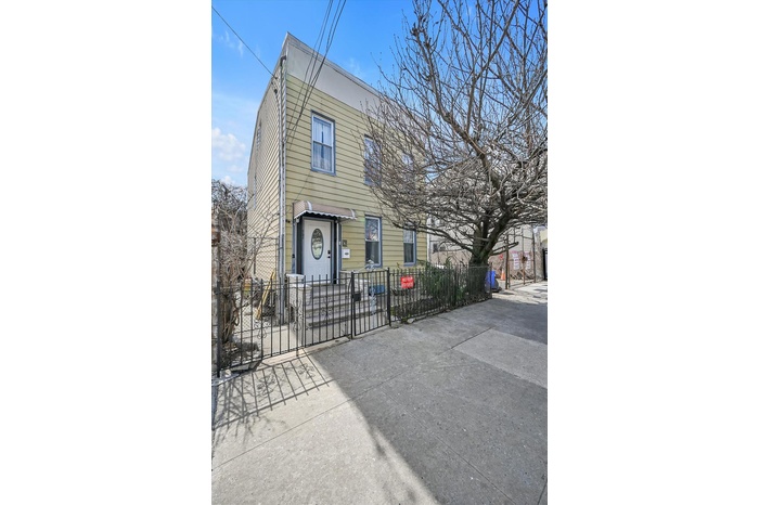 View of front of property with a fenced front yard and a gate