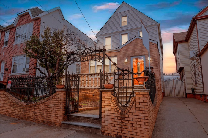 View of front of property featuring a gate, brick siding, and a fenced front yard