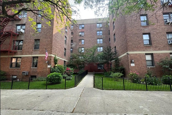 View of apartment building / complex featuring a fenced front yard and cooling unit
