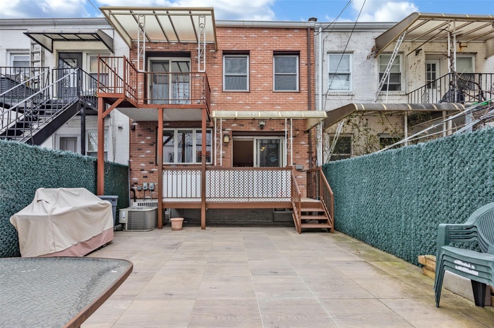 Rear view of house featuring brick siding and central AC unit