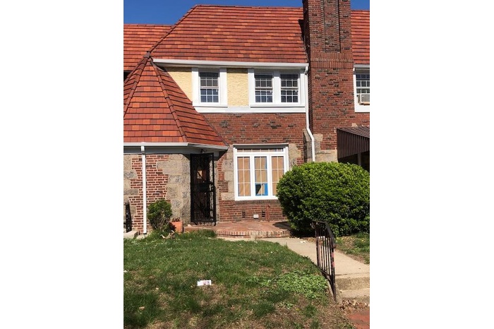 View of front of house featuring a front yard and brick siding