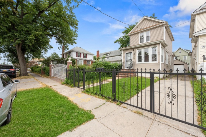 View of front of home with concrete driveway, a residential view, a fenced front yard, a gate, and a garage