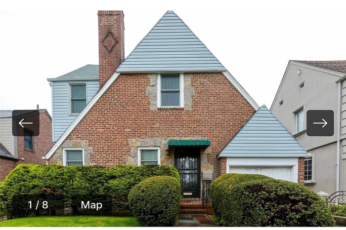 English style home featuring a chimney, a garage, and brick siding