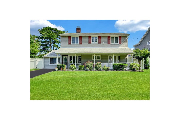 View of front of house featuring a porch, a gate, a chimney, and a front yard