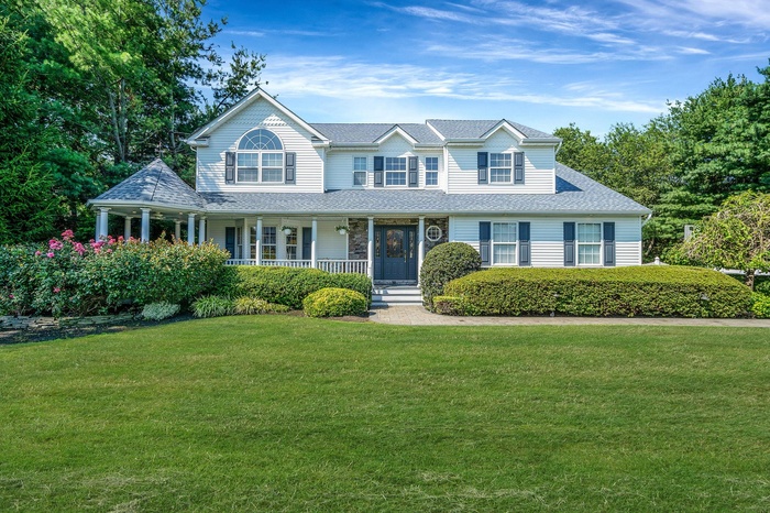View of front of house with a front yard, covered porch and gazebo