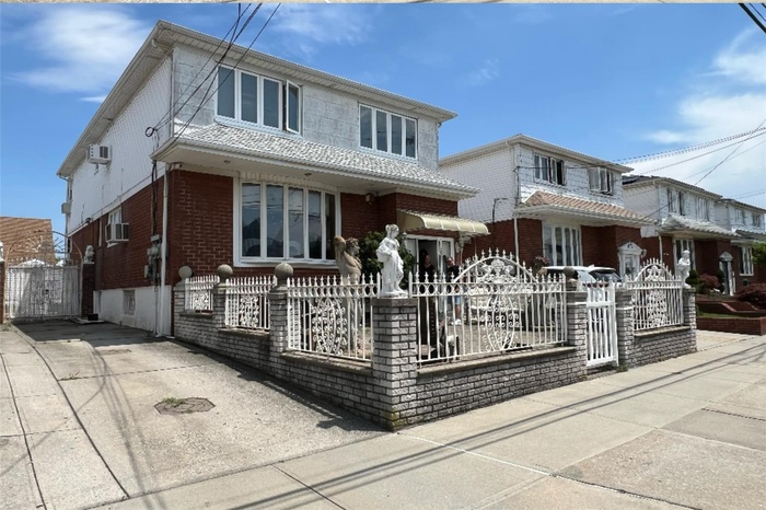 View of front of house featuring a gate, brick siding, a fenced front yard, and concrete driveway
