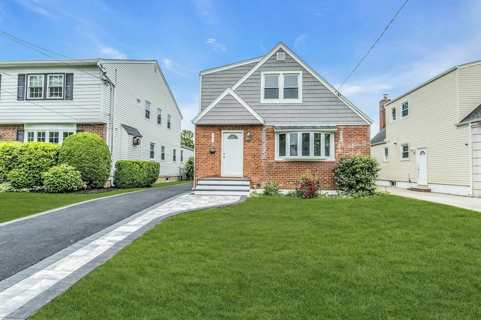 View of front of property featuring brick siding and a front lawn
