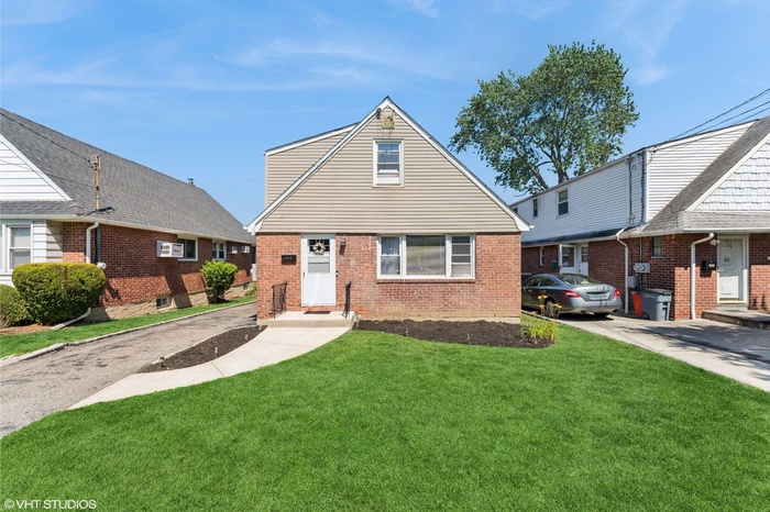 View of front facade featuring brick siding and a front lawn