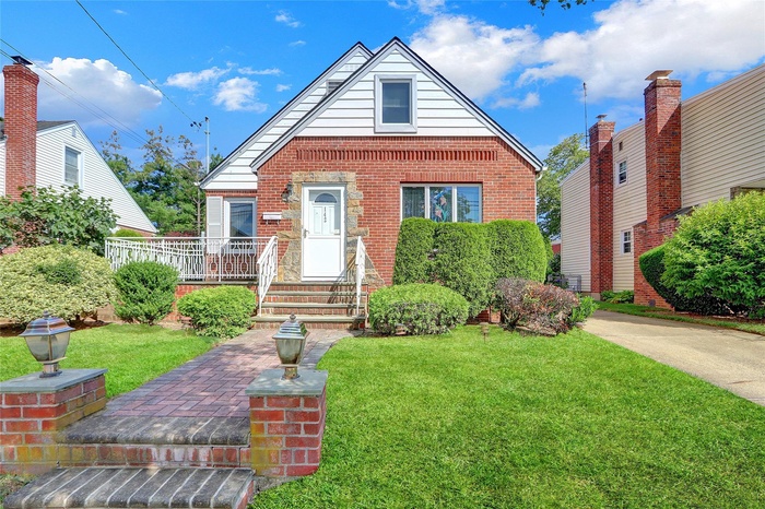Bungalow with a front yard and brick siding