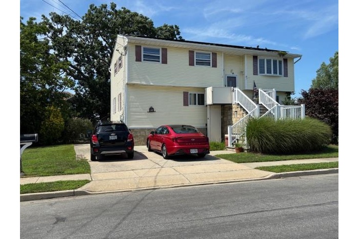 Split foyer home with stairway and concrete driveway