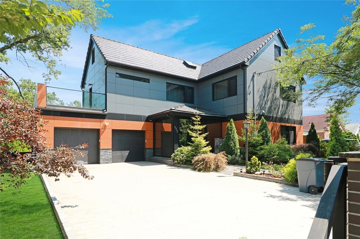 Contemporary home featuring concrete driveway and a garage
