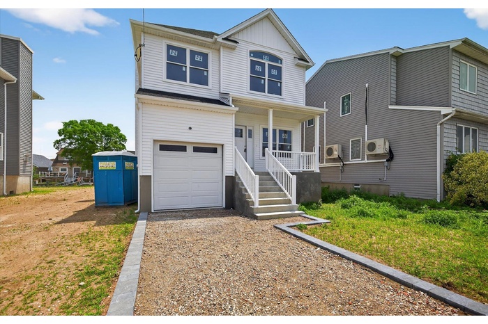 View of front of house featuring a garage, a porch, driveway, and board and batten siding