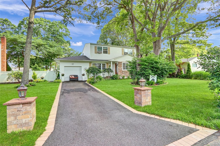 View of front facade featuring asphalt driveway and an attached garage