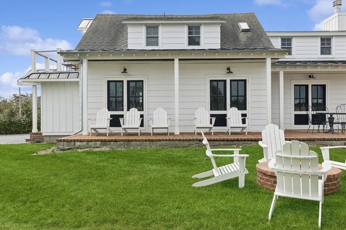 Rear view of property featuring a shingled roof, metal roof, and a lawn