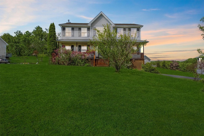 View of front of house featuring covered porch and a yard
