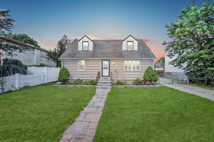 Cape cod house featuring roof with shingles