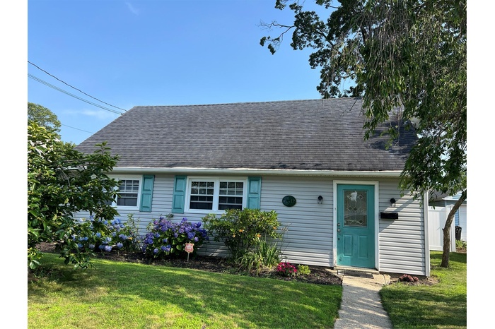 Cape cod-style house with a front yard and a shingled roof