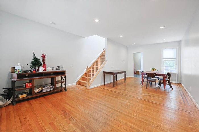 Dining room with stairs, light wood-type flooring, and recessed lighting