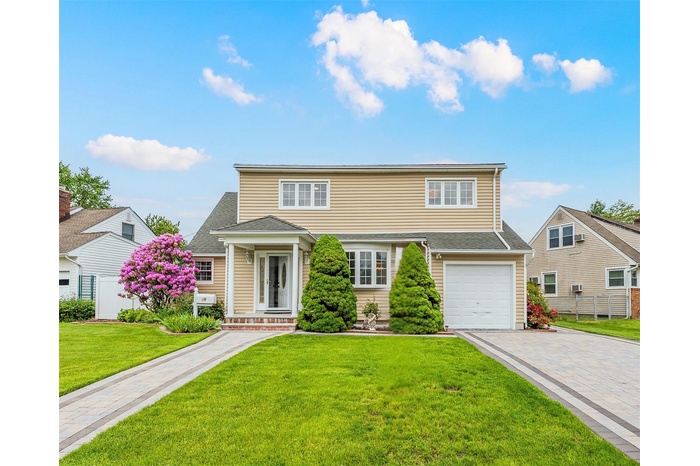 Traditional home featuring decorative driveway and a garage