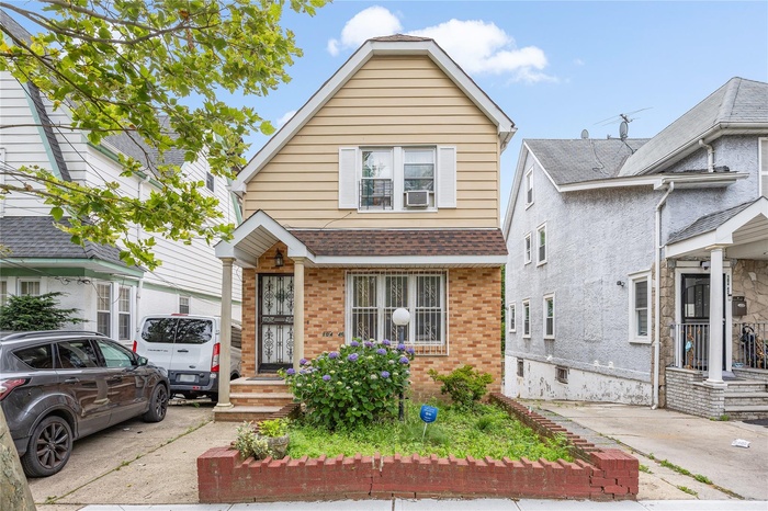 View of front of house featuring brick siding and cooling unit