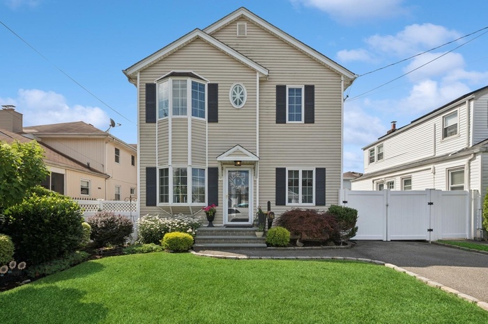 Traditional home with a gate and asphalt driveway