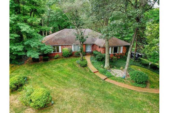 Ranch-style home with brick siding, a front lawn, and roof with shingles