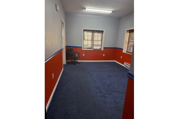 Carpeted empty room with a baseboard radiator and baseboards
