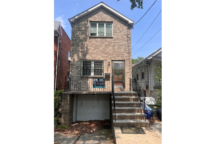 View of front facade with an attached garage and brick siding