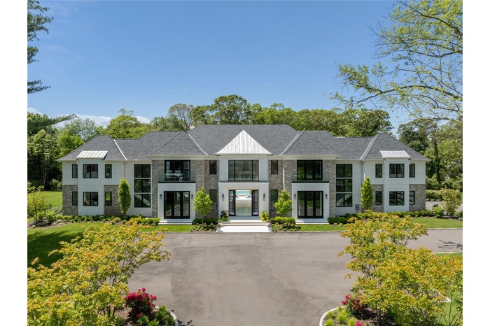 Modern home featuring french doors, stone siding, and a shingled roof