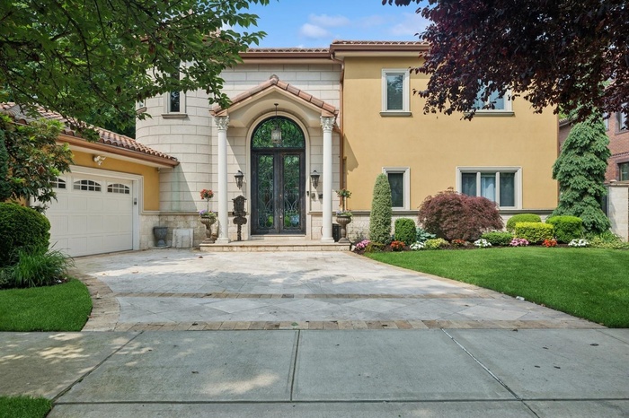View of front of house featuring french doors, stone siding, driveway, a garage, and stucco siding
