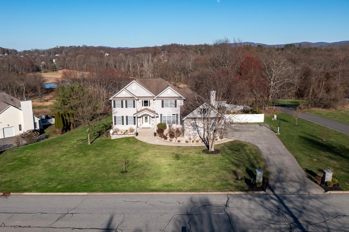 Traditional home with driveway and a front yard