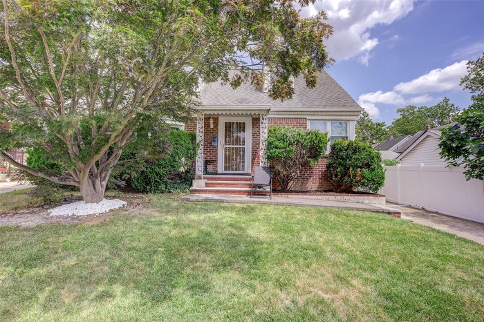 View of front of house featuring brick siding and a shingled roof