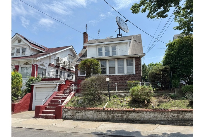View of front of property featuring brick siding, stairs, and a chimney